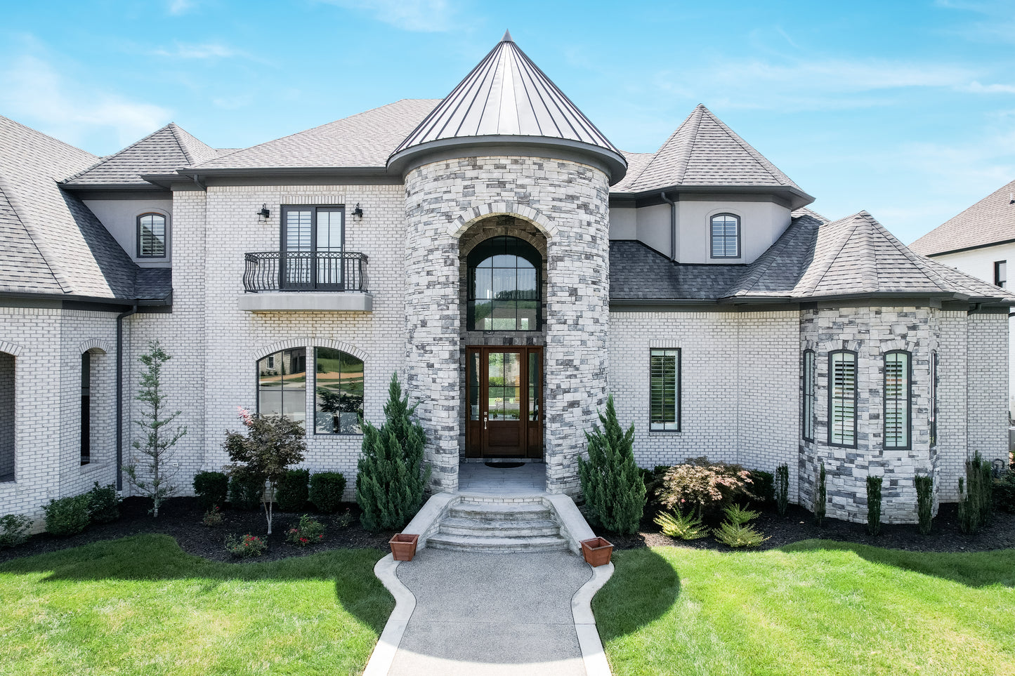 Luxurious mansion with stone entrance and well-maintained lawn