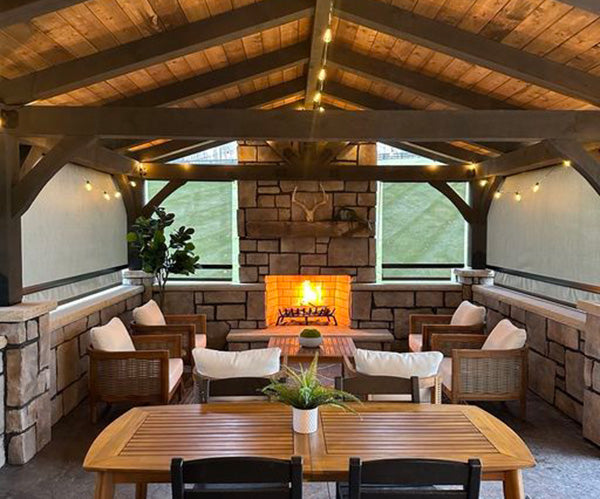 Indoor rustic setting with stone walls, wooden beams, and a fireplace.