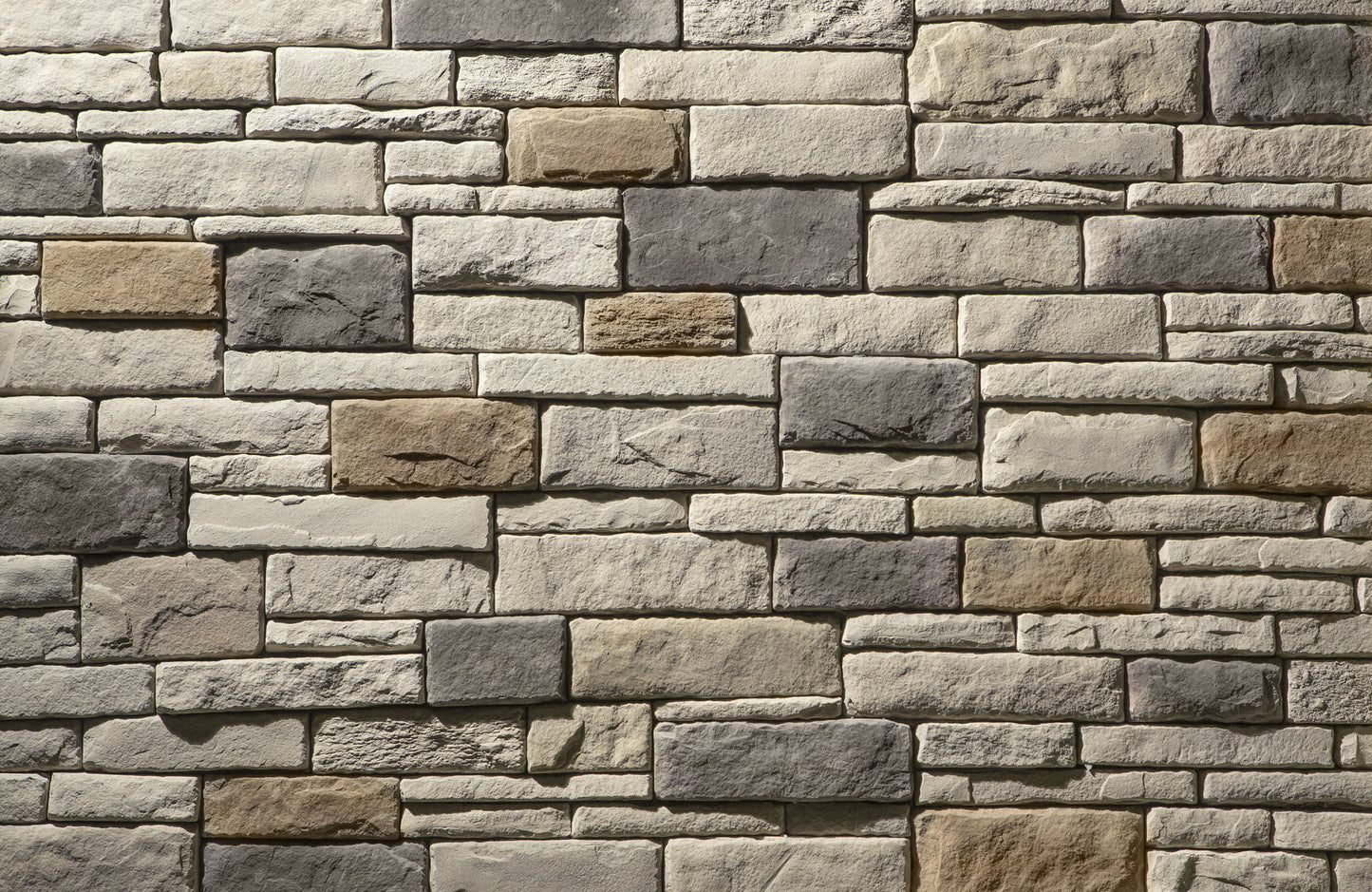 Pattern of stacked stone bricks in various shades of gray and brown.
