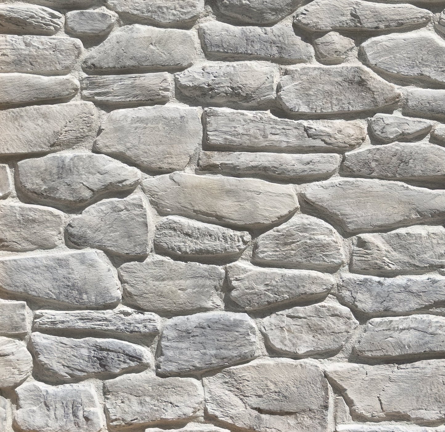 Close-up of a stone wall with varying stone sizes and shapes.