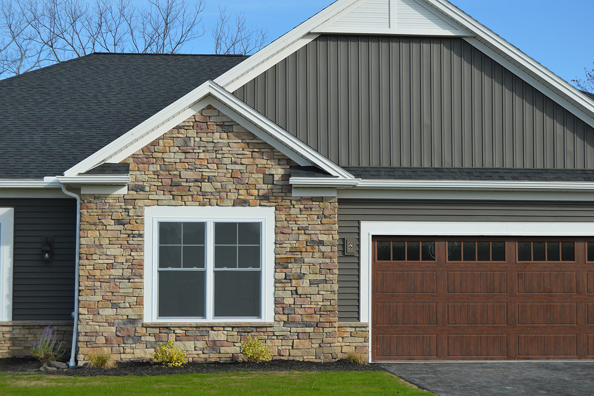 House exterior with stone facade, window, and garage door.
