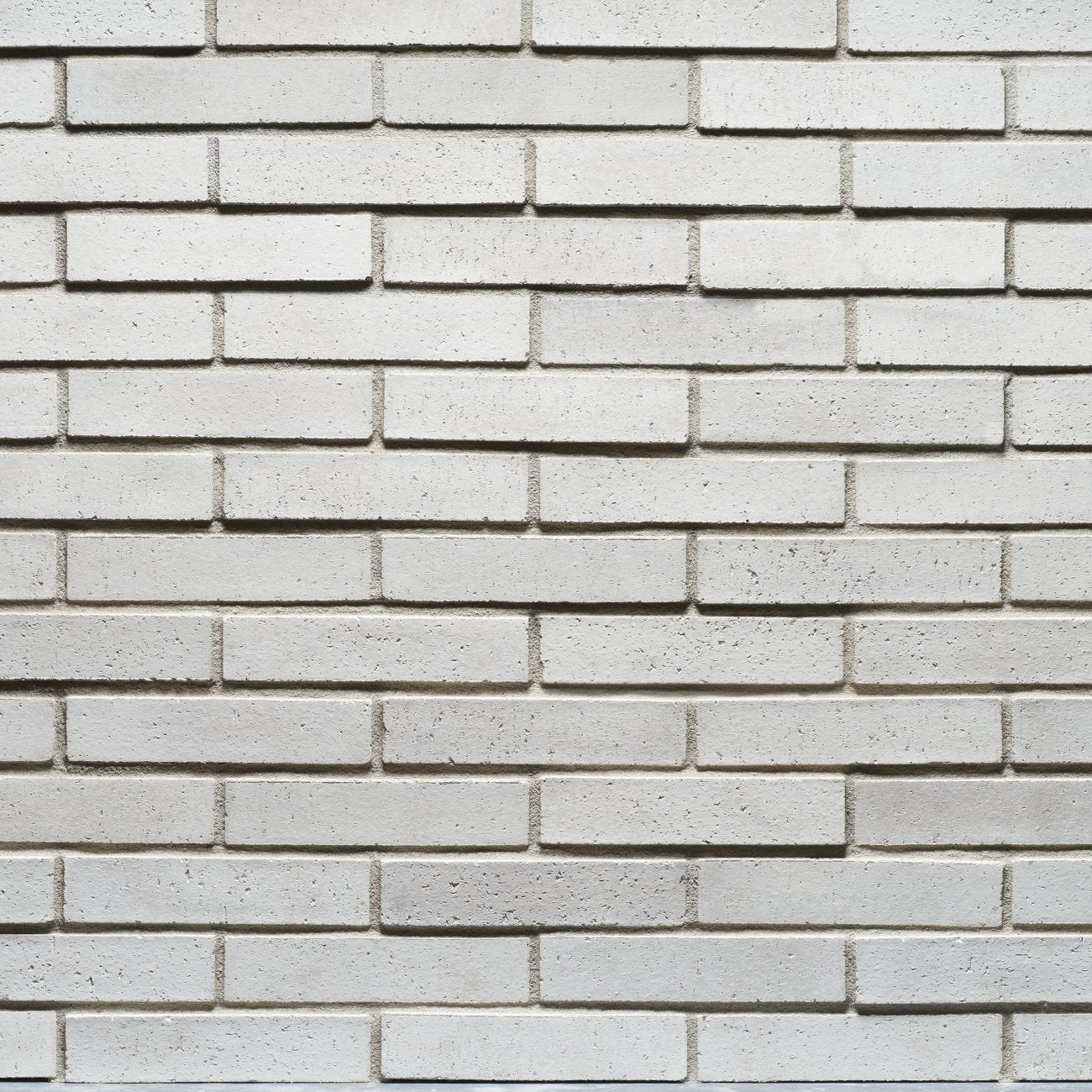 Cultured Stone Loften Tenley Brick veneer featuring soft white and cream tones, slim linear brick profile, and refined masonry texture