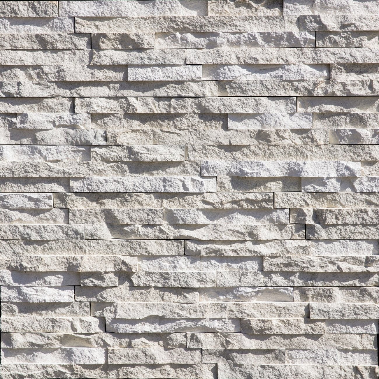 Eldorado Sea Cliff European Ledge stone veneer in soft gray and tan hues with linear, chiseled stone texture