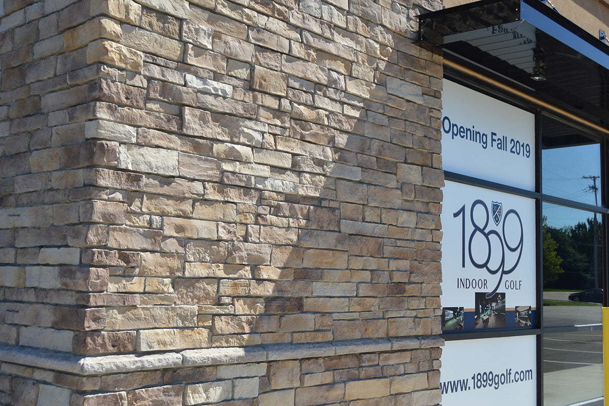 Stone building facade with a sign for 1859 Golf, indicating an opening in Fall 2019.
