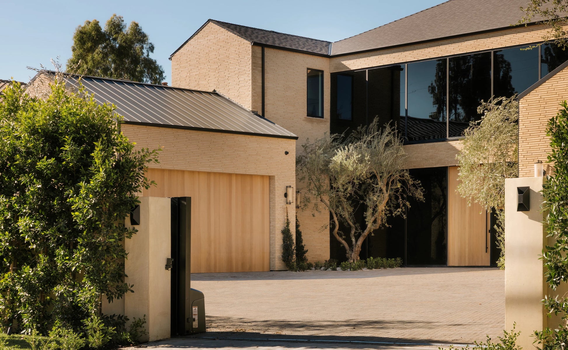 Modern house with a driveway and trees in the foreground