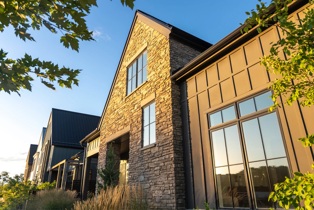 Warm-toned ledgestone gables and tall windows on a contemporary home, featuring Creative Mines® Bison Craft Peak Ledge.