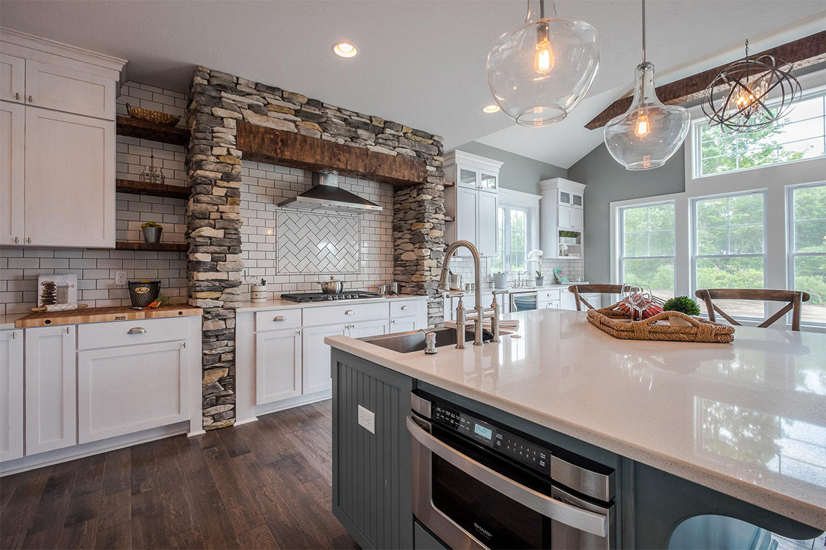 Modern kitchen with white cabinets, stone backsplash, and stainless steel appliances.