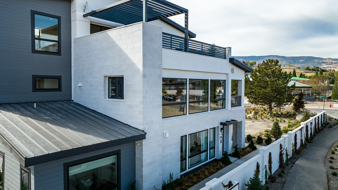 Light textured rectangular stone on a modern multi-level home with dark window frames, featuring Creative Mines® Brighthorizon Craft Flamed Rectangle.