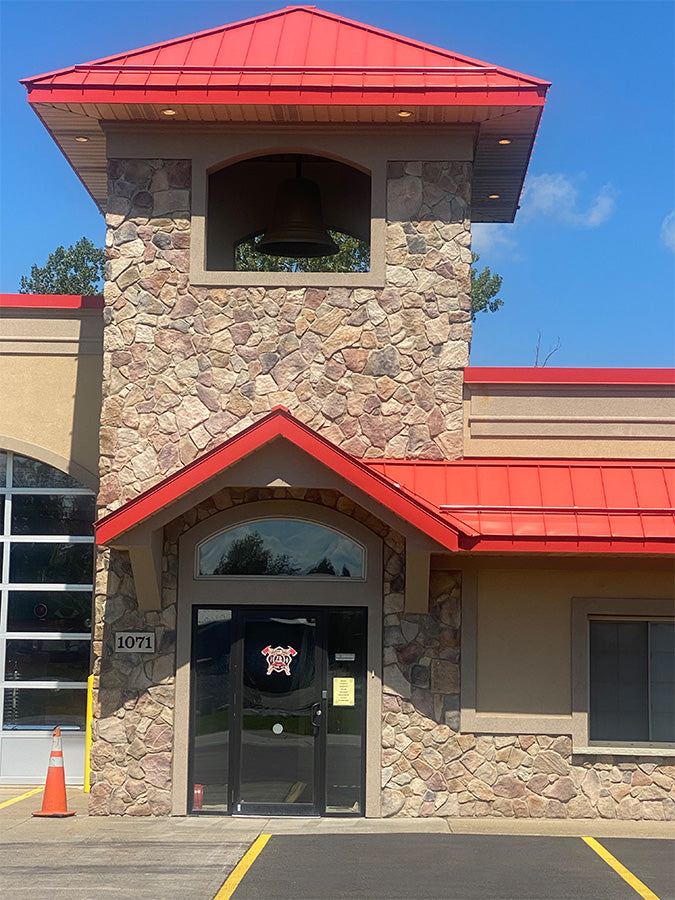 Building entrance with stone facade and red roof
