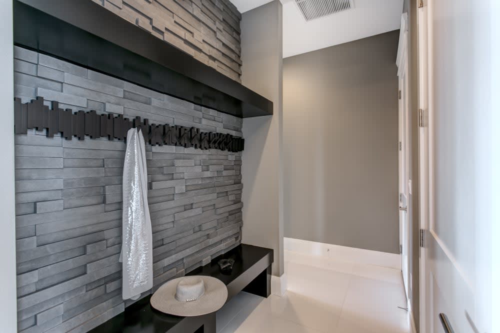 Carbon Pro-Fit Modera Ledgestone accent wall with a black bench and coat hooks.