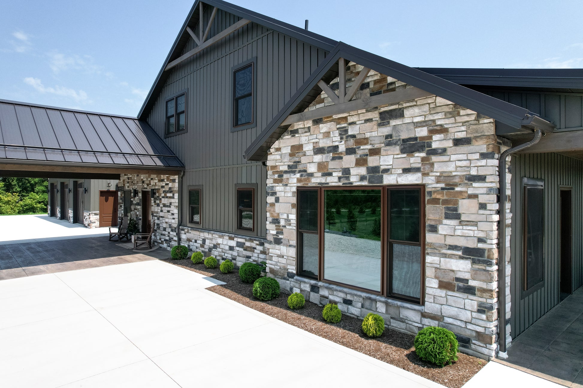 Modern house with stone facade and glass windows on a clear day