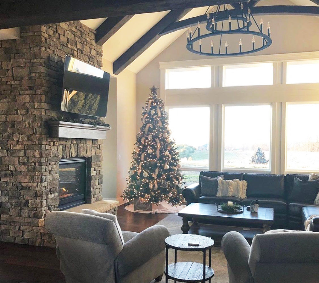 Living room with stone fireplace, Christmas tree, and festive decor.