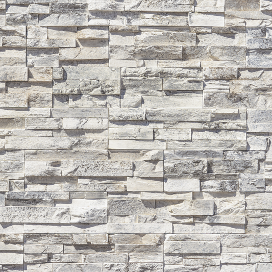 Light gray and white stacked stone veneer wall cladding with textured rectangular stones in a staggered layout.