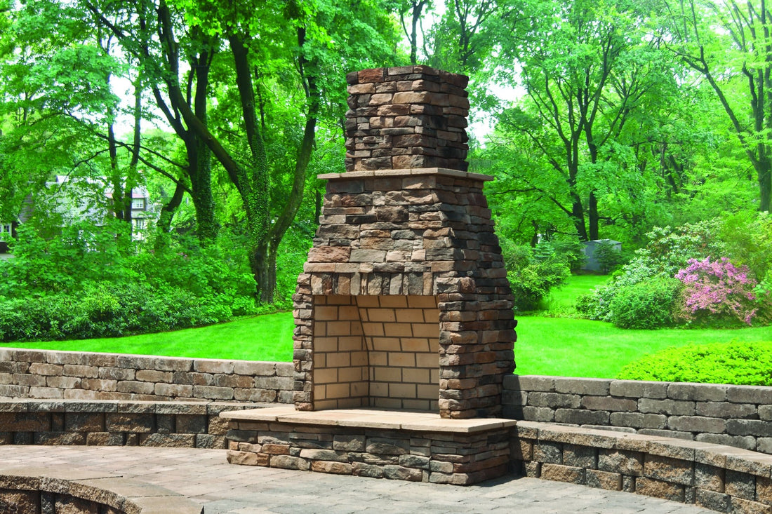 Ledgestone outdoor fireplace centered on a curved stone patio wall amid trees, featuring Dutch Quality Sienna Weather Ledge.