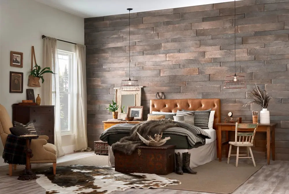 Wide stone planks across a bedroom accent wall behind a wood-framed bed, featuring Dutch Quality Winesburg Weathered Plank.