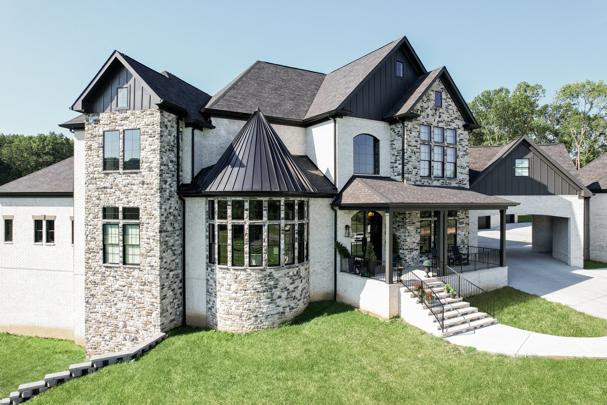 Stately house with stone facade and large windows on a clear day