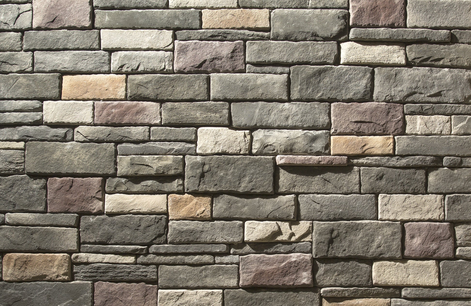 Pattern of stone bricks in various shades of gray, brown, and beige.