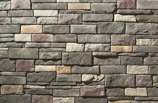 Pattern of stone bricks in various shades of gray, brown, and beige.
