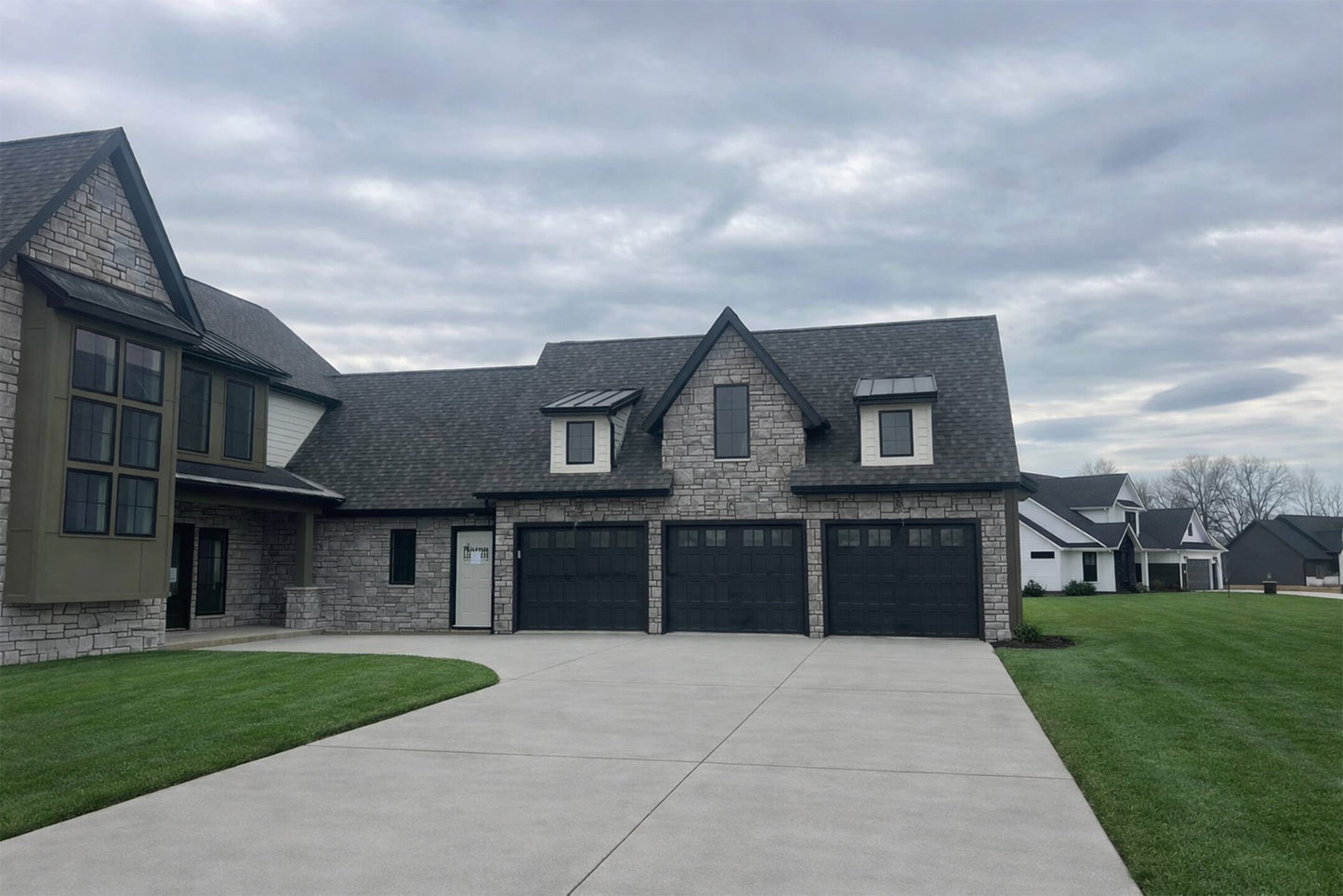 Two-story house with a garage under a cloudy sky