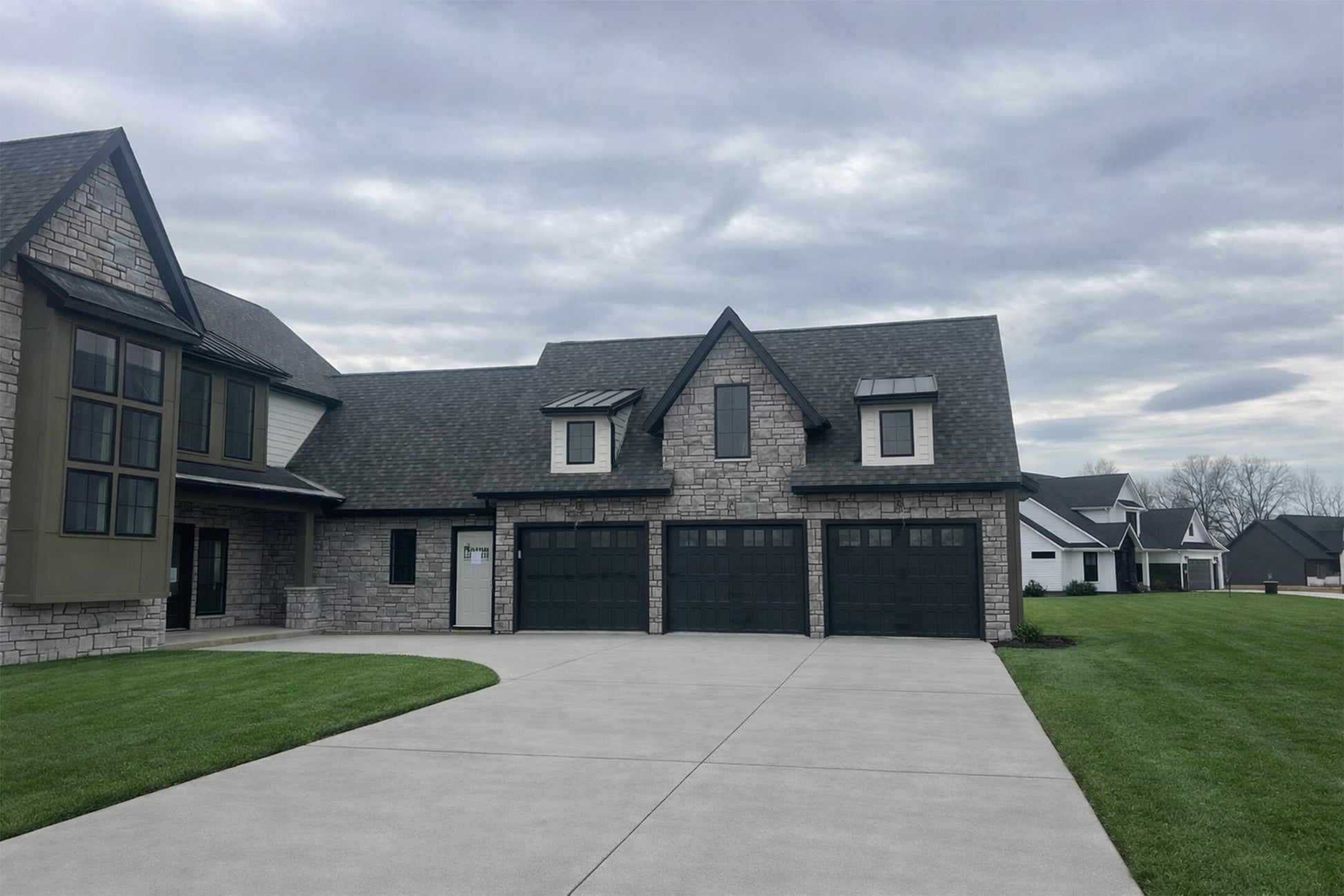 Two-story house with a garage under a cloudy sky