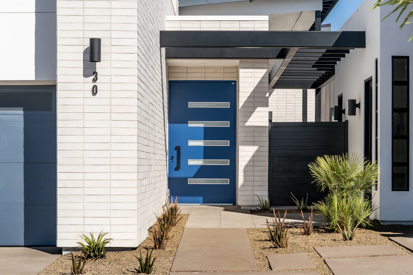 Modern house entrance with a blue door and white walls