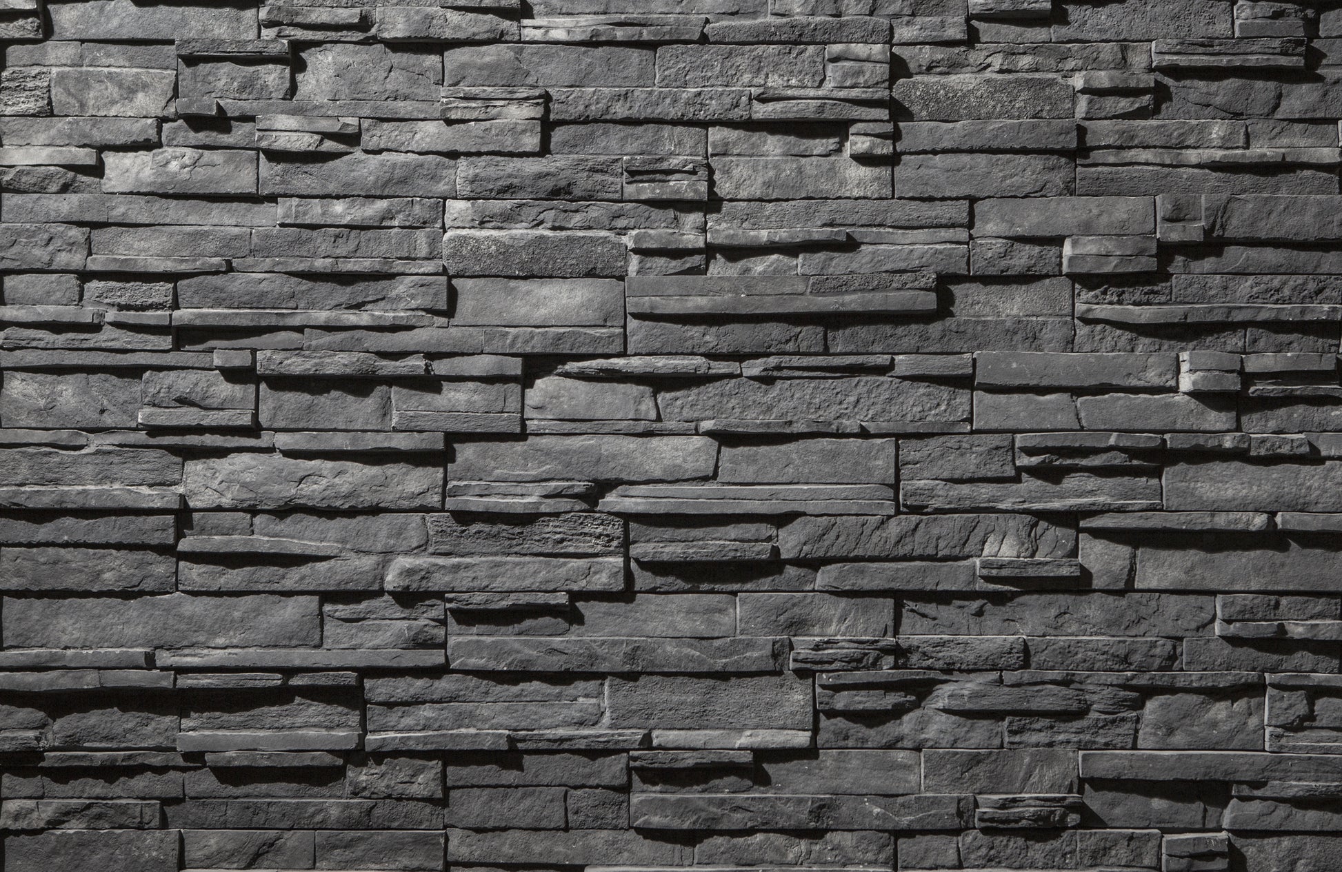 Textured stone wall with varying shades of gray