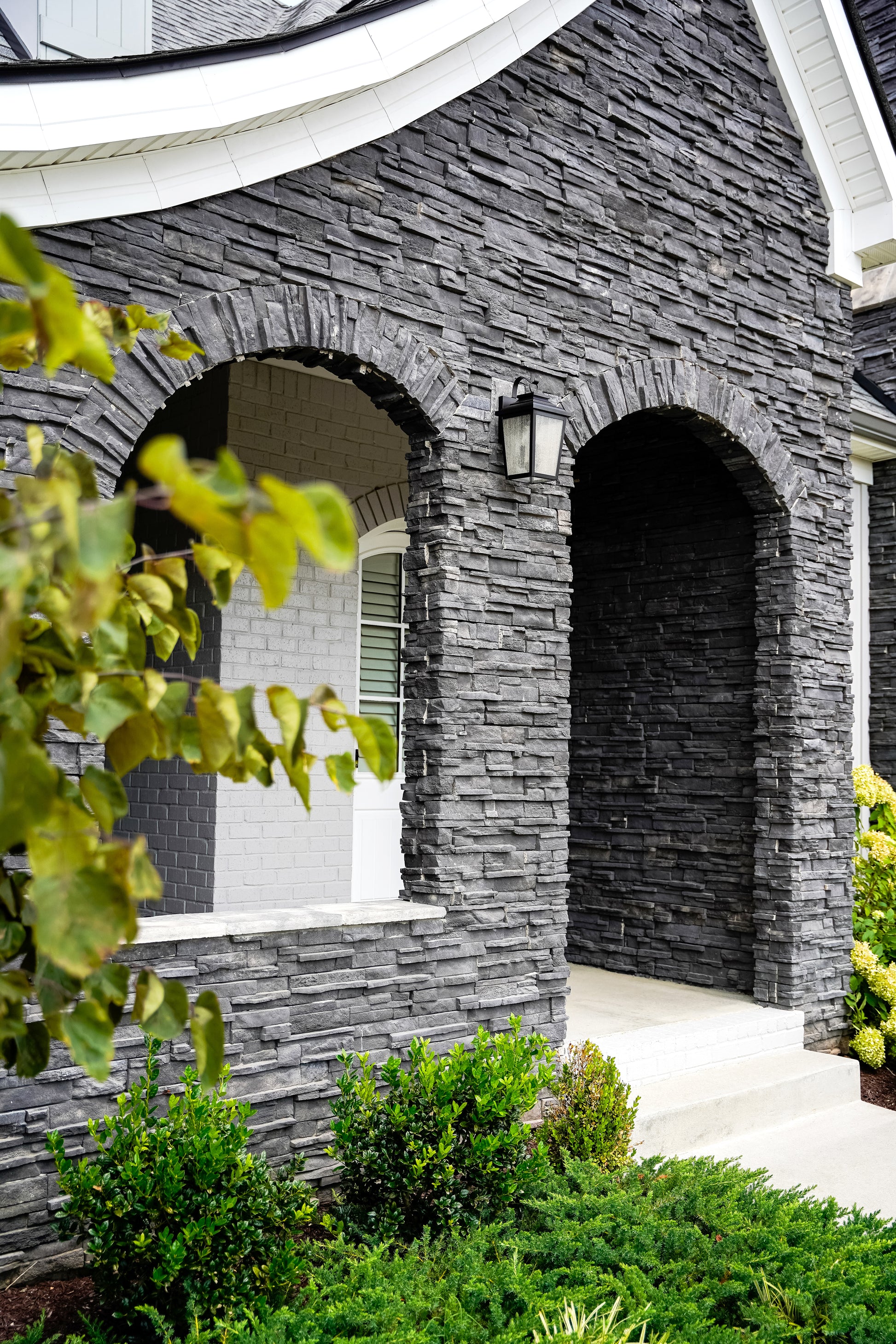 Stone archway entrance to a house with greenery around