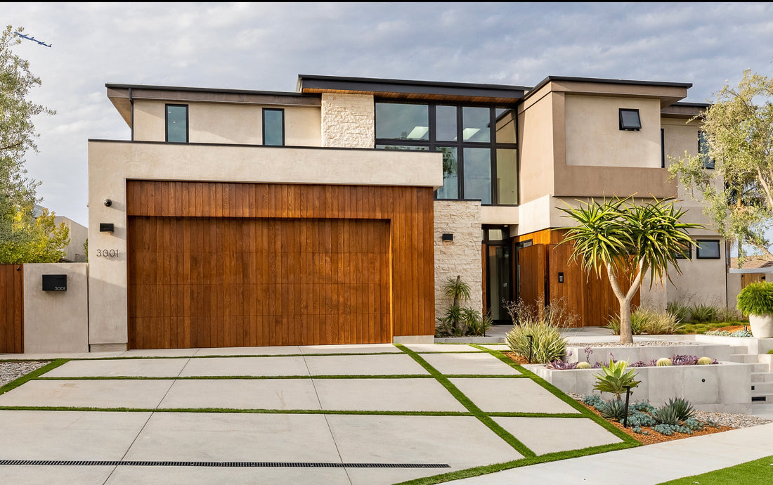 Pale horizontal stone around a contemporary two-story home with a wood garage door, featuring Creative Mines® Sandollar Craft Urban Strip.