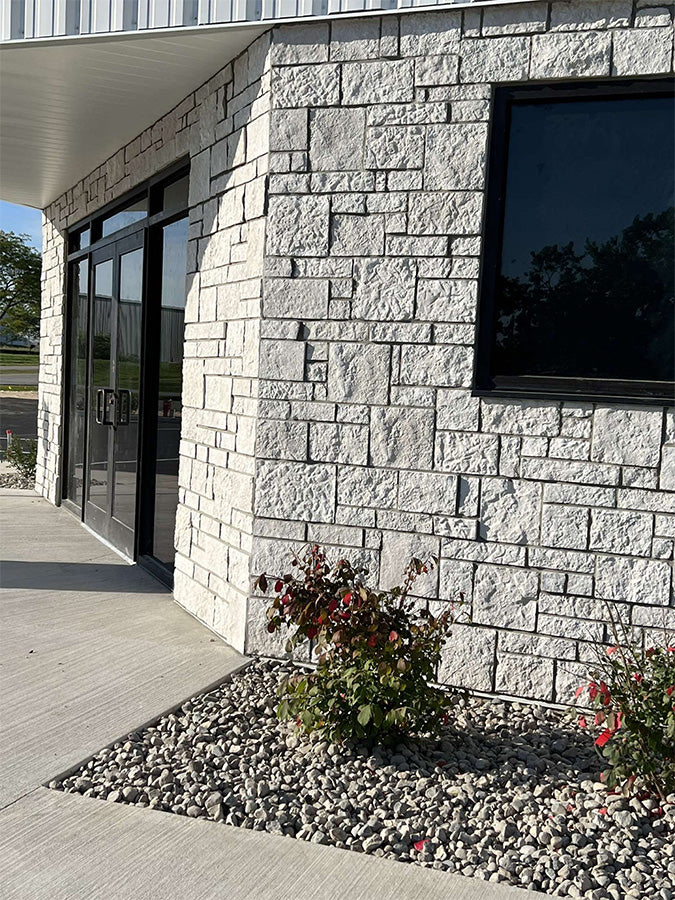 Stone building exterior with a small garden area.