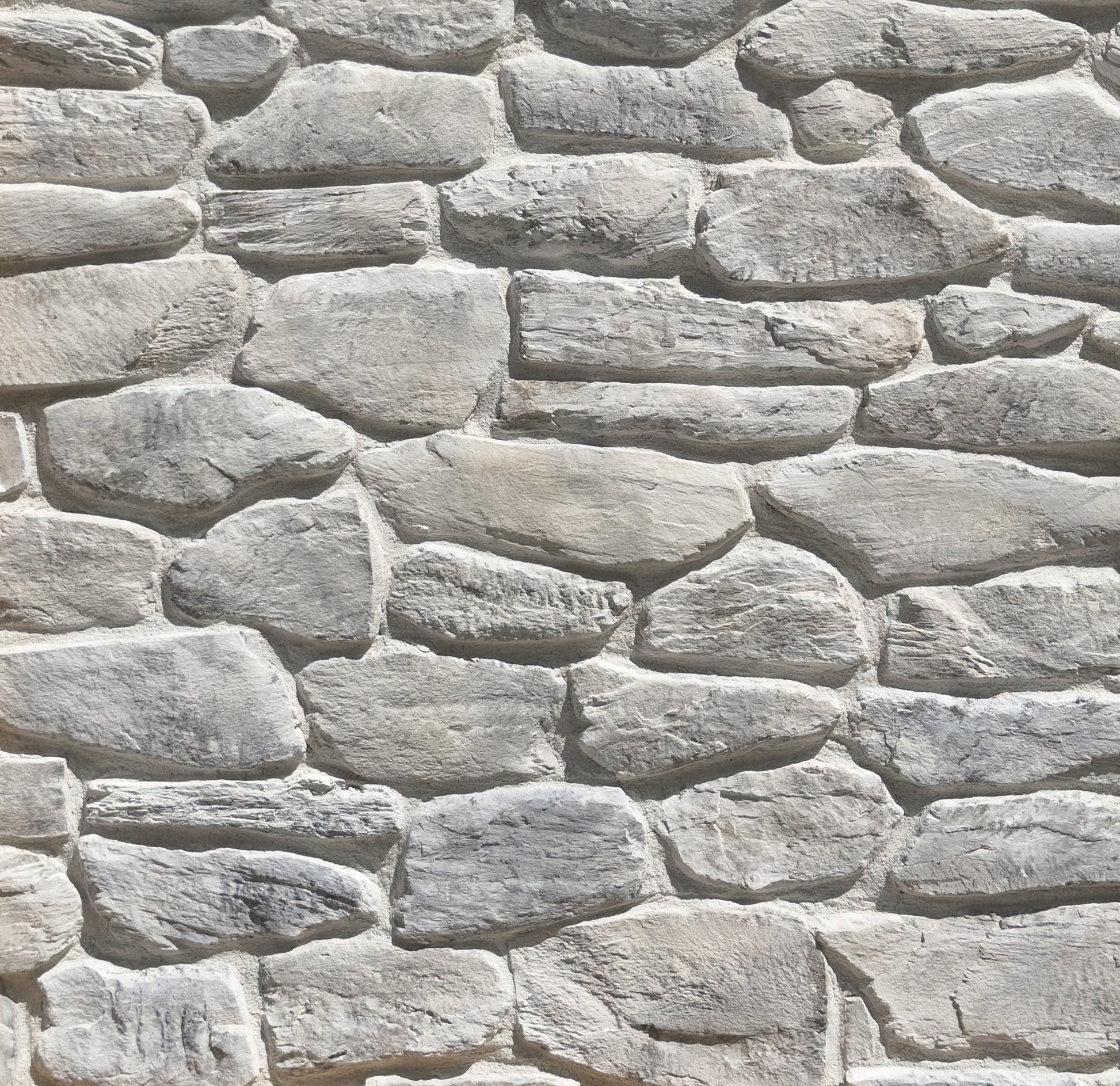 Close-up of a stone wall with varying stone sizes and shapes.