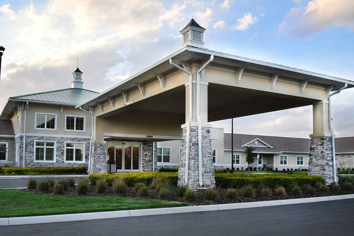 Community center or clubhouse with a large covered entrance and stone pillars.