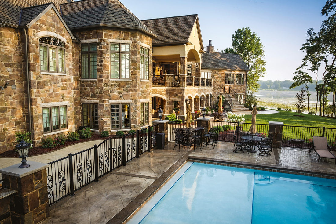 Warm old-world stone on a large home overlooking a fenced pool and patio, featuring Casa Di Sassi Euro Old World.