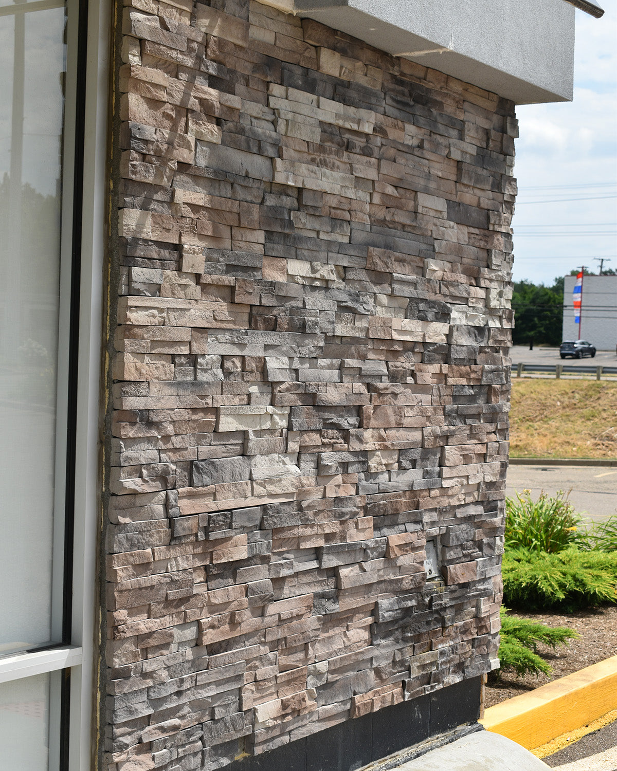 Textured stone wall on a building exterior with a clear sky background
