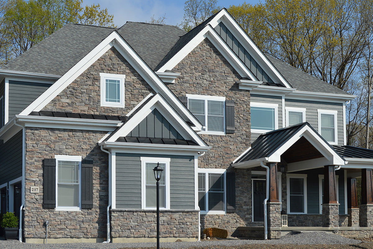 Two-story house with stone facade and gray roof
