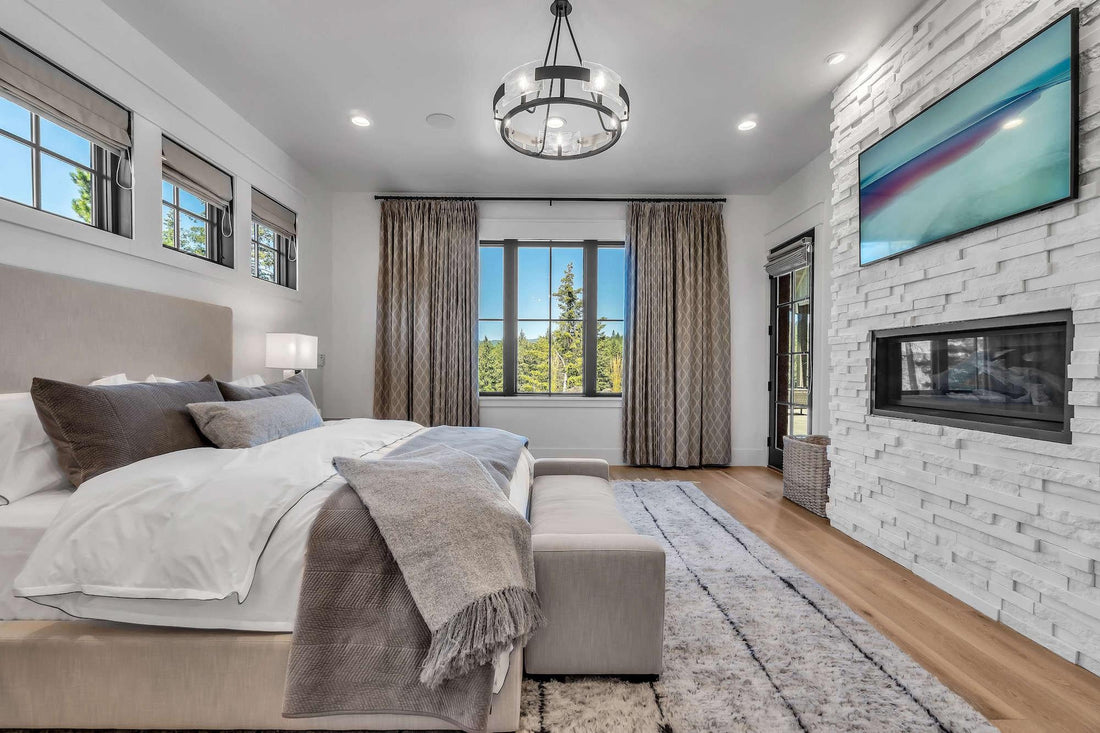 Light linear stone fireplace wall opposite a bed in a bright contemporary bedroom, featuring Cultured Stone Arctic Pro-Fit Terrain Ledgestone.