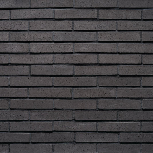 Cultured Stone Nori Tenley Brick veneer featuring deep charcoal and black tones, slim linear brick profile, and modern masonry texture