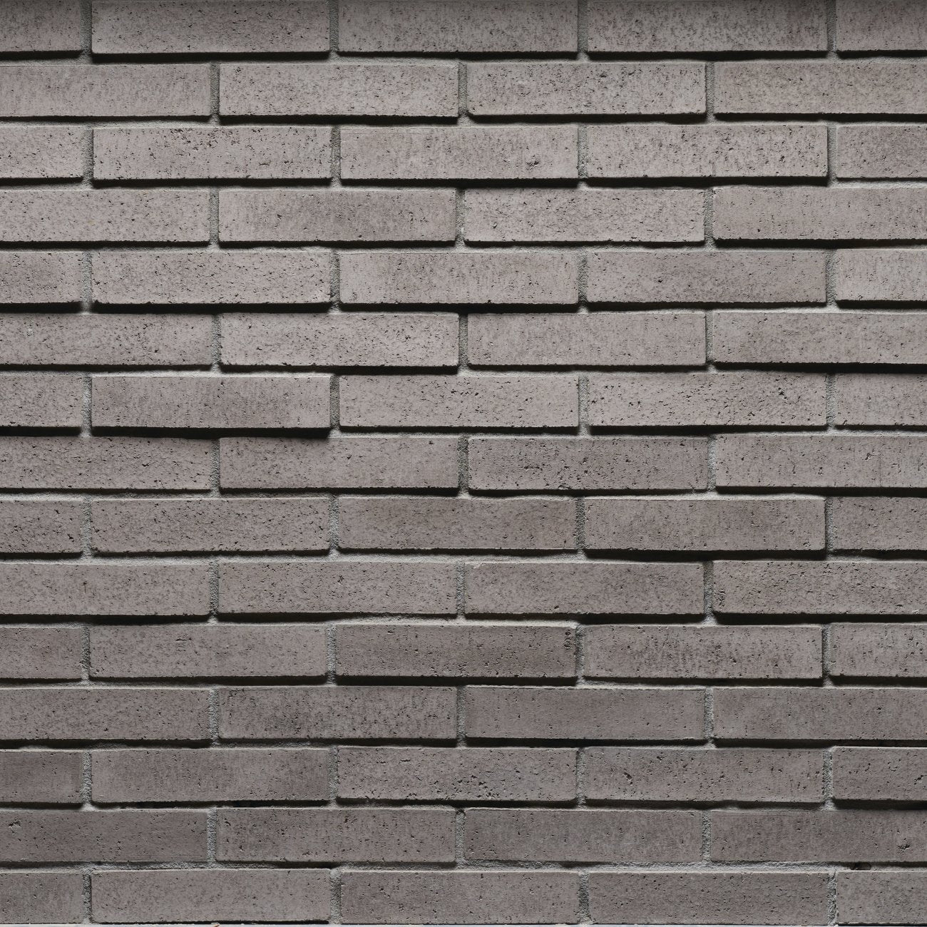 Cultured Stone Wildon Tenley Brick veneer featuring warm white and soft gray tones, slim linear brick profile, and refined masonry texture