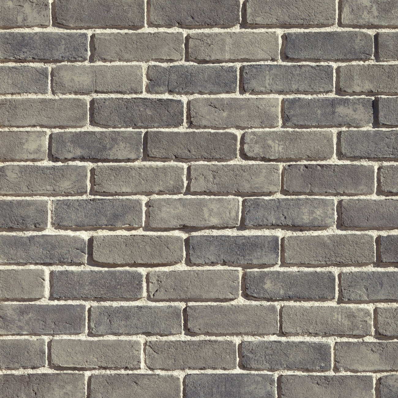 Eldorado Ashland TundraBrick thin brick-style stone veneer in soft gray, taupe, and brown tones with textured surface