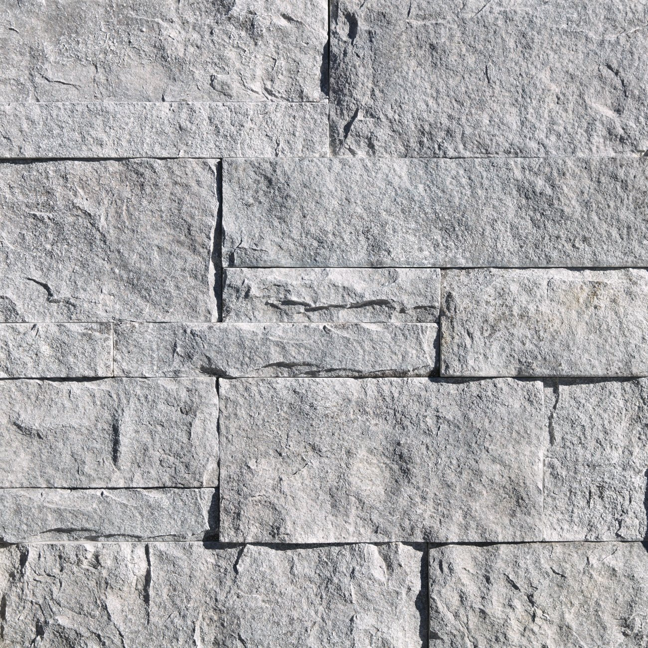 Eldorado Cannonade Cut Coarse Stone veneer in warm gray and charcoal hues with linear, split-face stone texture