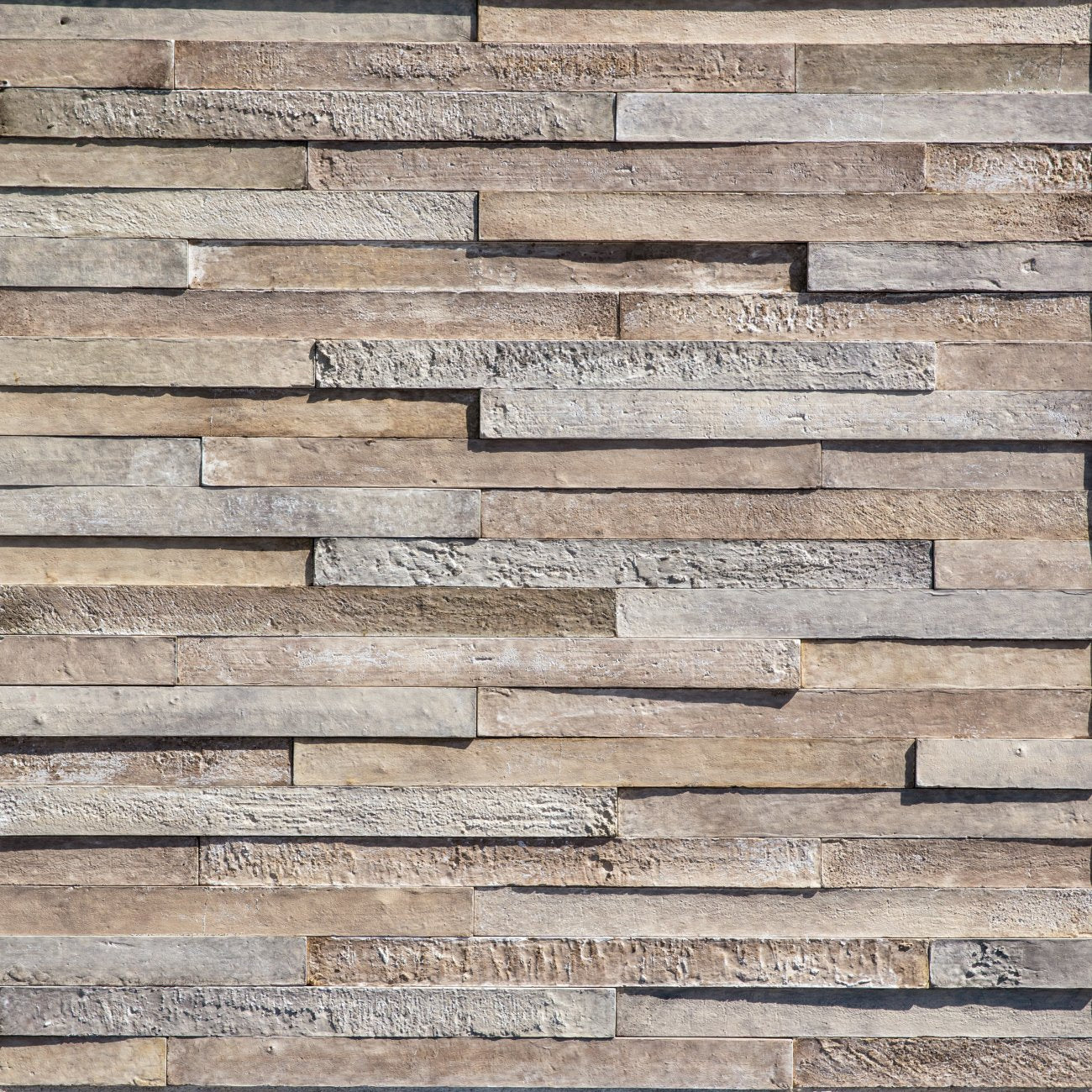Eldorado Farola LoreioBrick thin brick-style stone veneer in warm red, tan, and brown tones with textured surface