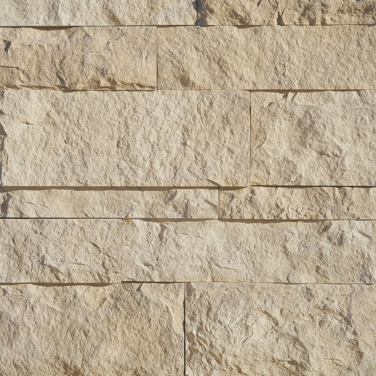 Eldorado Oyster Cut Coarse Stone veneer in light gray and beige hues with linear, split-face stone texture