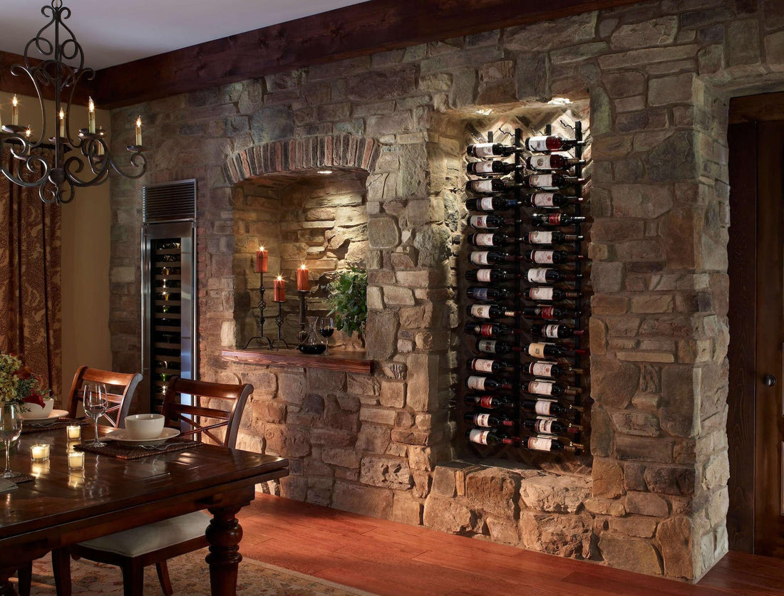 Rustic stone wall with recessed bottle storage beside a dining table, featuring Eldorado Orchard Cypress Ridge.