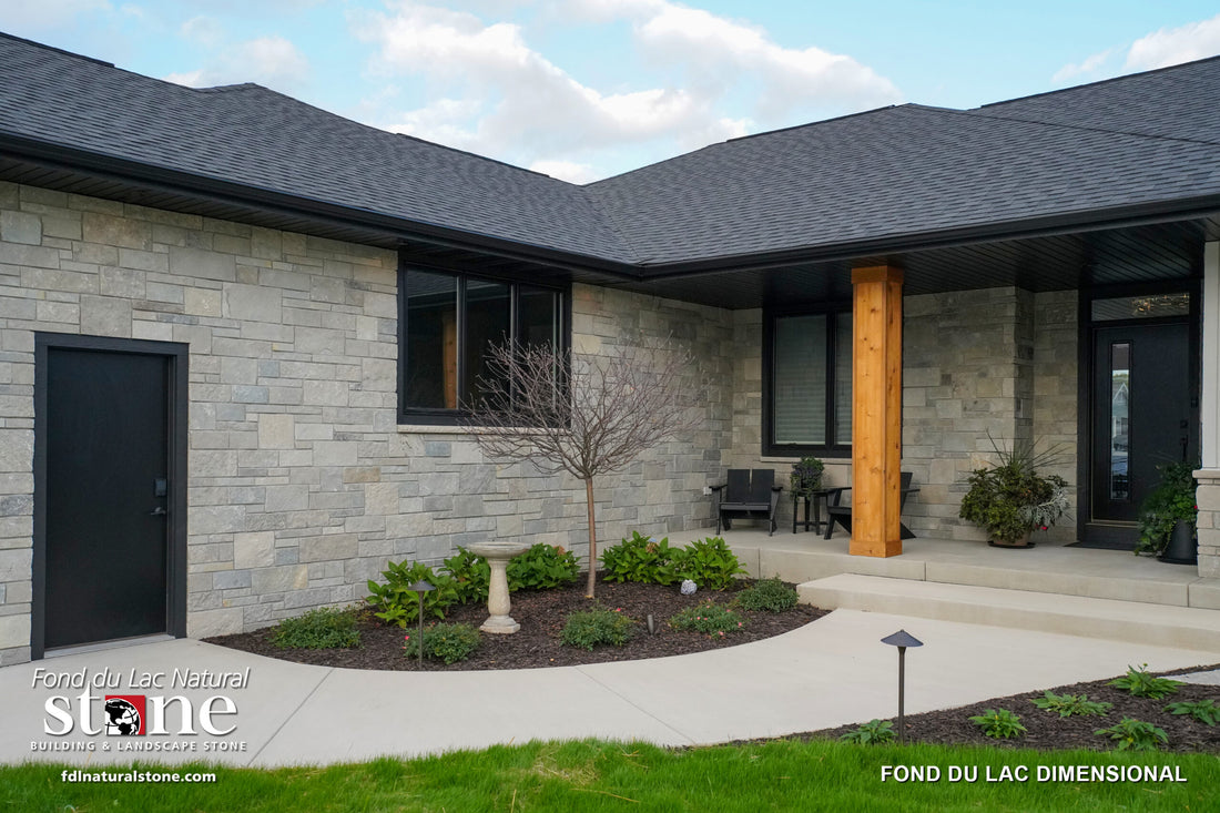 Light dimensional stone around a modern home entry with timber porch posts, featuring Fond du Lac Dimensional.