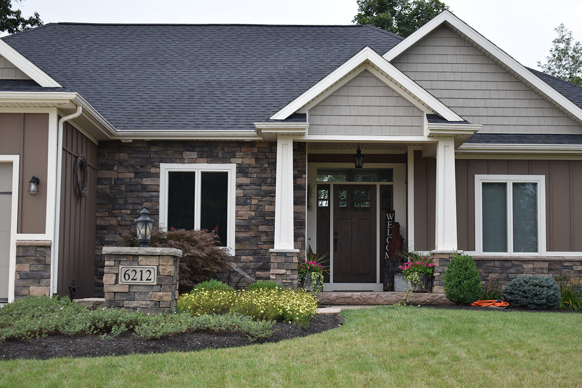 Front view of a two-story house with a well-maintained lawn and garden.