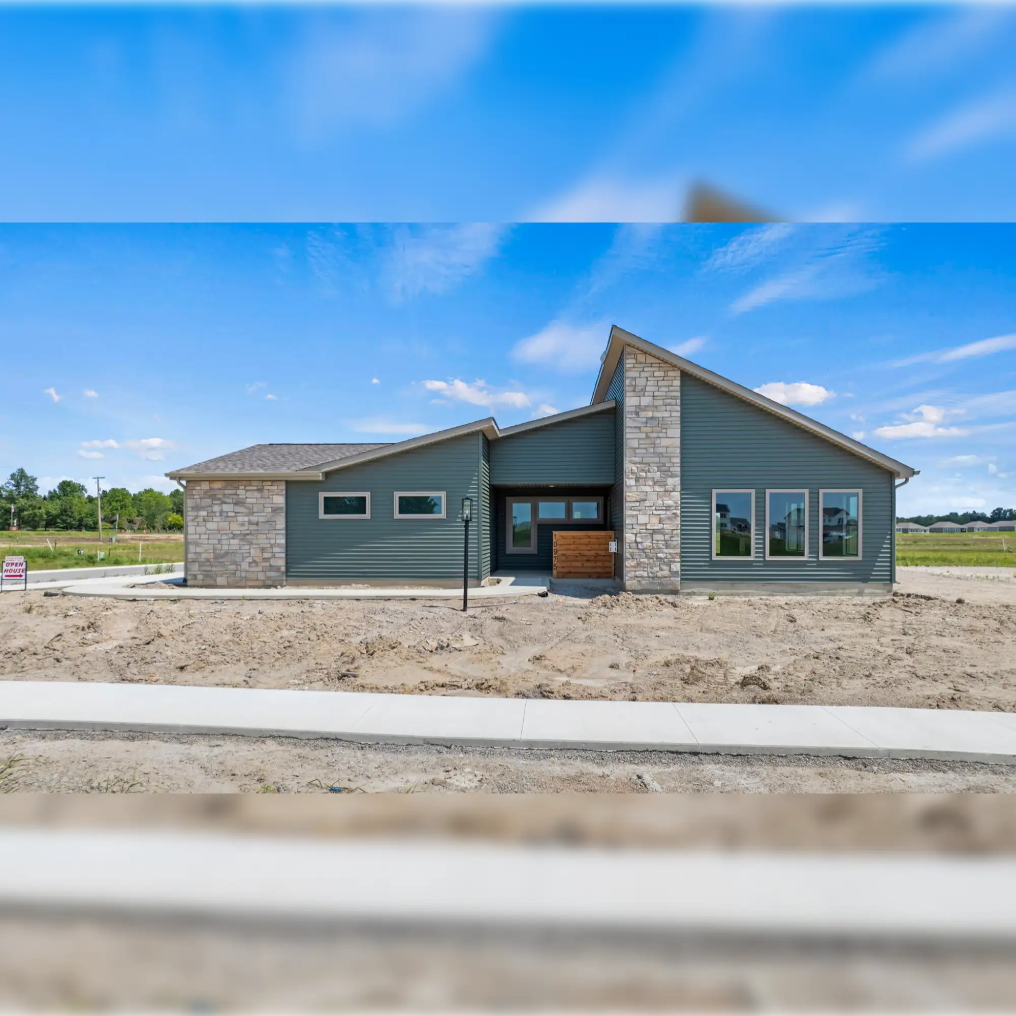 Modern gray house with stone accents and large windows.