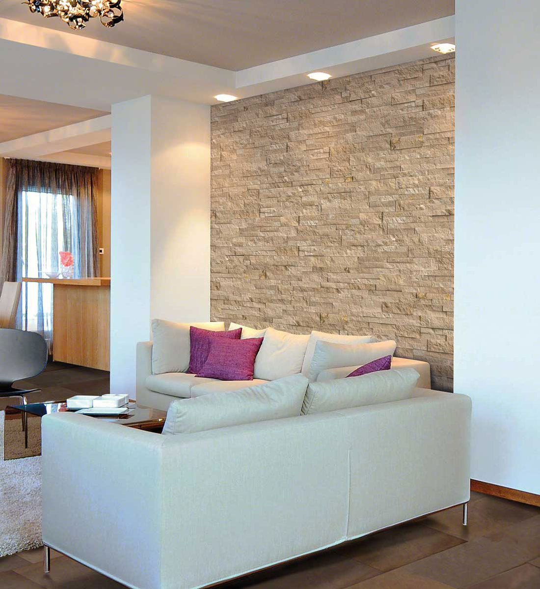 Pale natural stone accent wall behind a white sofa in a bright living room, featuring MSI® Rockmount Durango Cream.