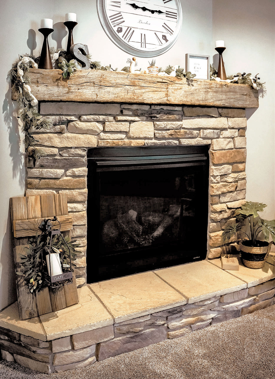 Ledgestone fireplace surround with a wood mantel and a raised stone hearth, featuring Provia Osage Ledgestone.