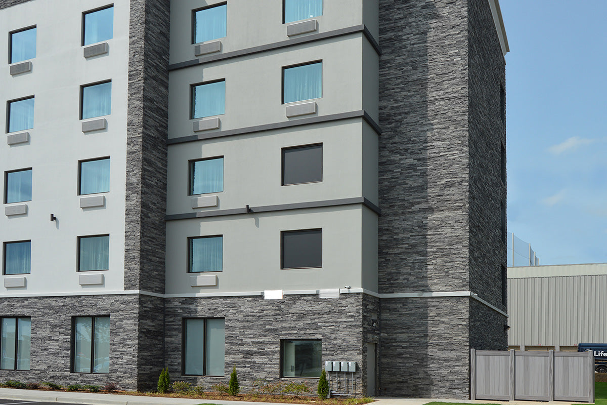 Multistory building with a modern architectural design featuring gray and white facade.