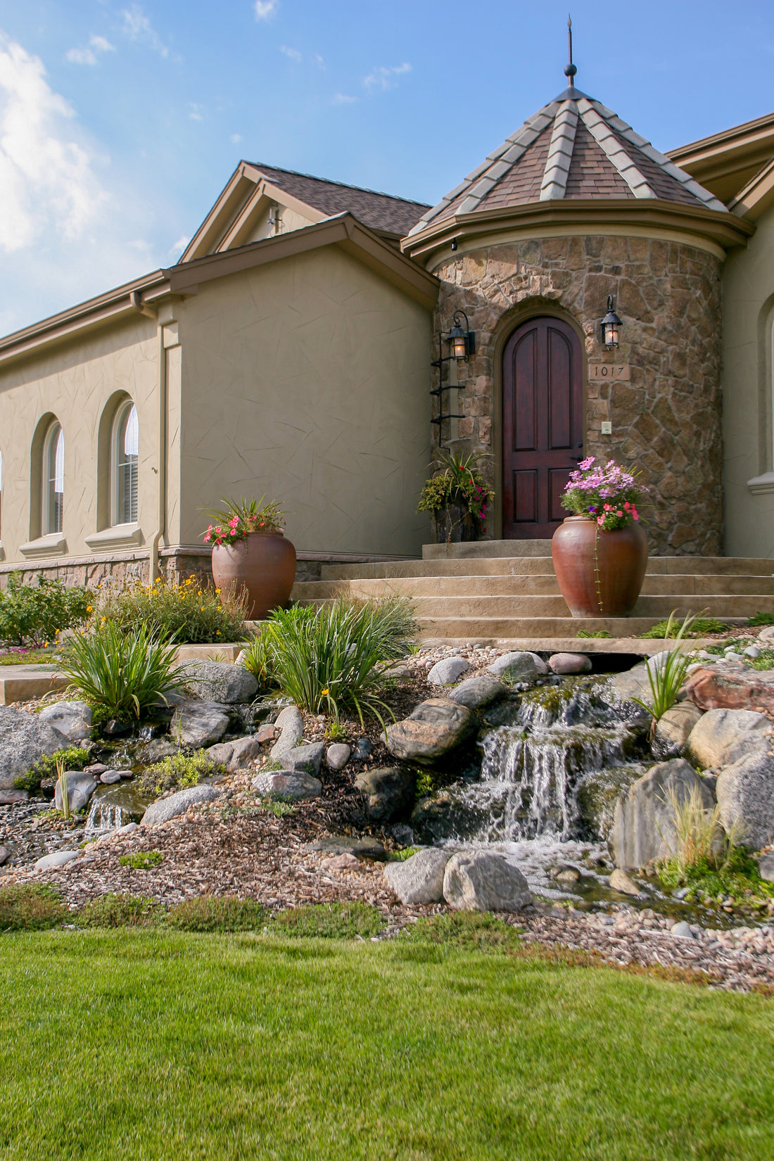 Fieldstone entry tower overlooking a landscaped rock-and-water garden, featuring Sunset Stone Georgetown Fieldstone.