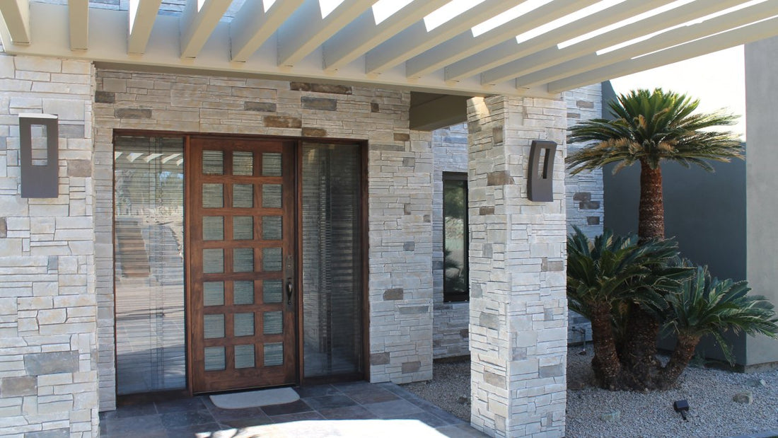 Light tight-cut stone around a wood front door under an open beam canopy, featuring Versetta Mission Point Tight-Cut.